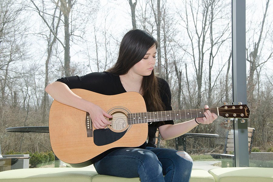 Abbigayle Richards with her guitar outside