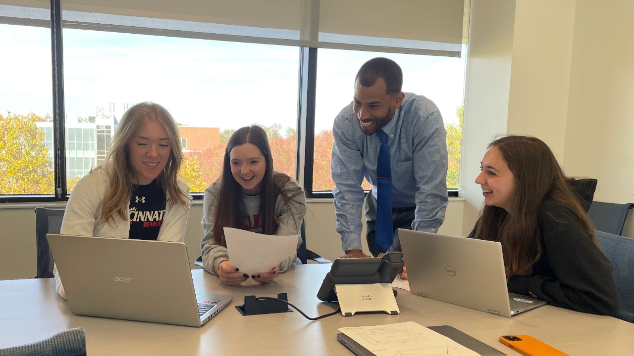 Three female students working with a professor