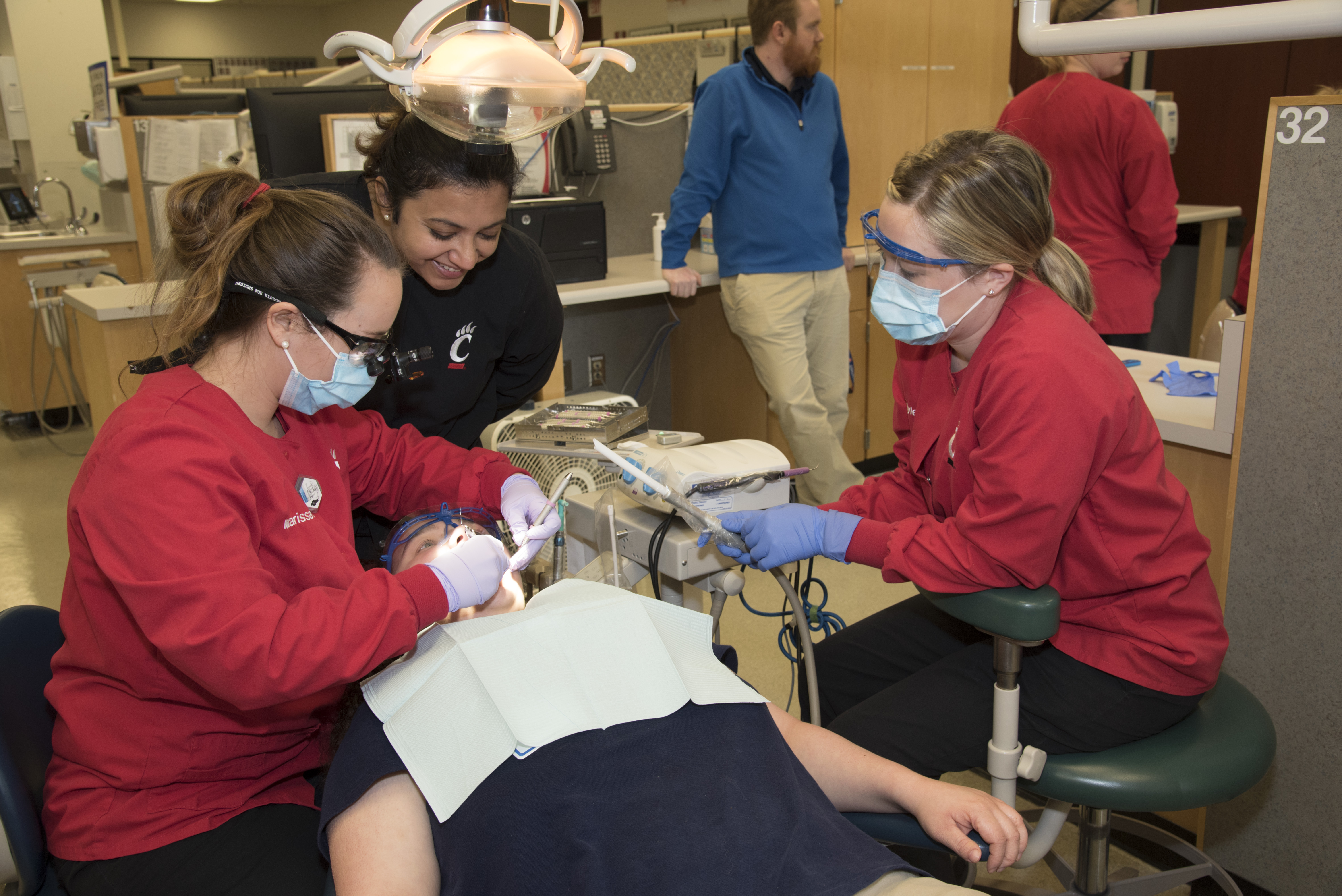 dental hygiene students working with a patient