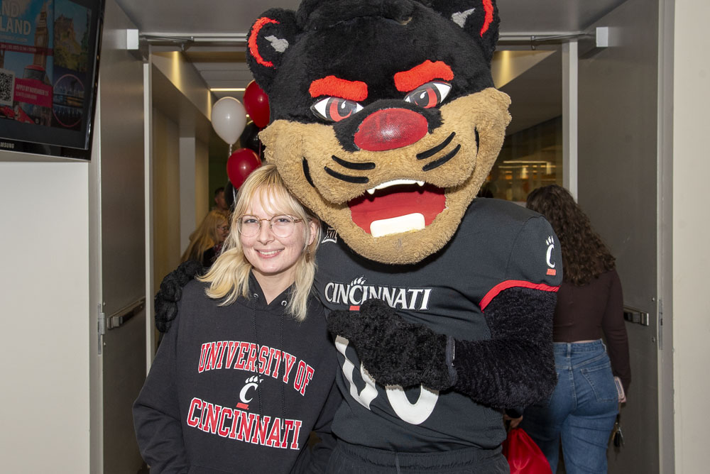 bearcat mascot outside pointing to college signage